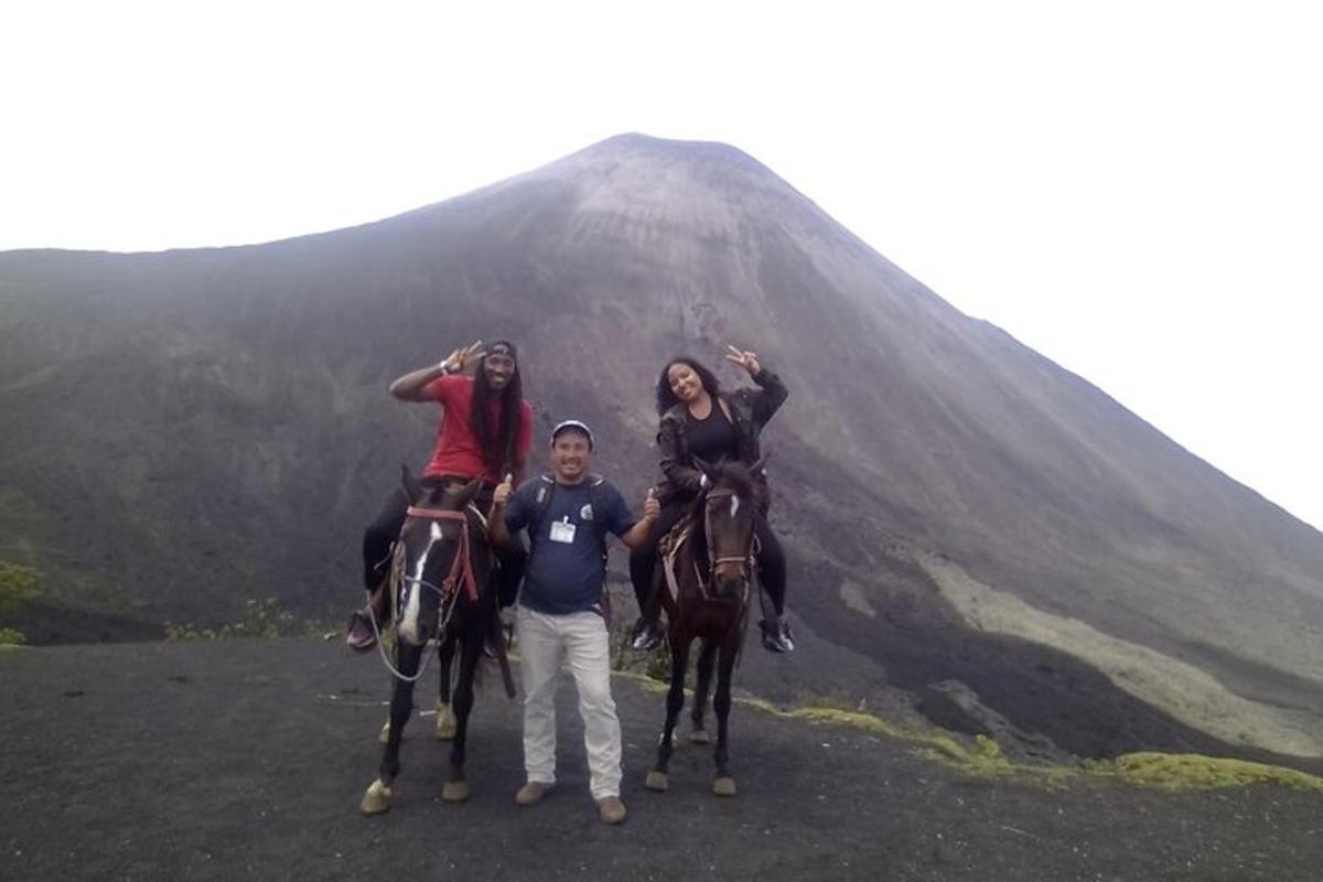 three people on horses standing in front of a mountain