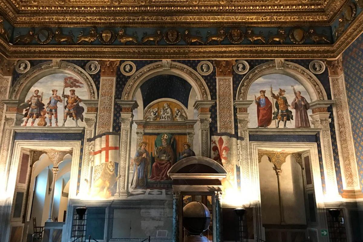 uma sala com pinturas no teto de um edifício