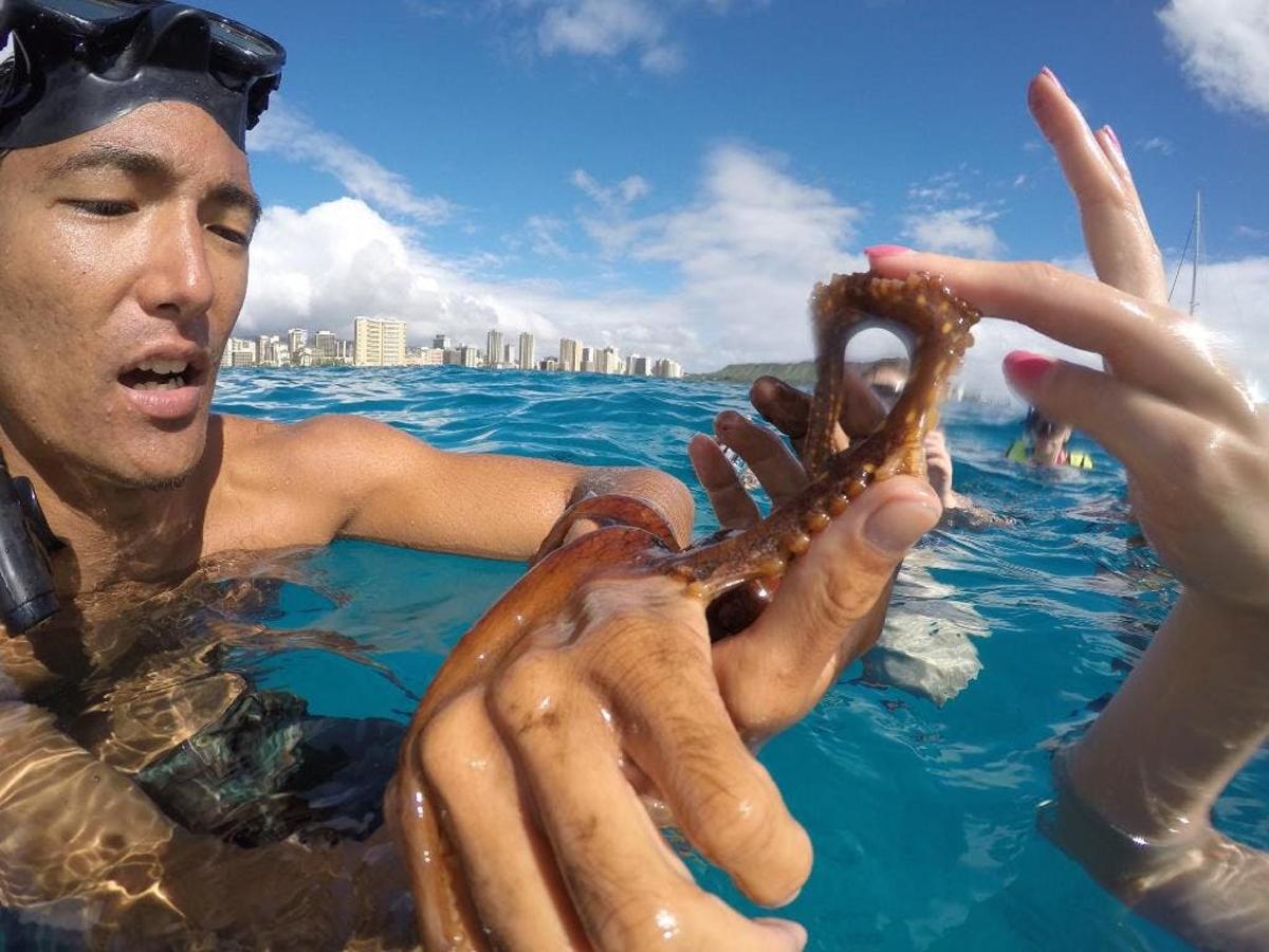 a man holding a octopus in the water