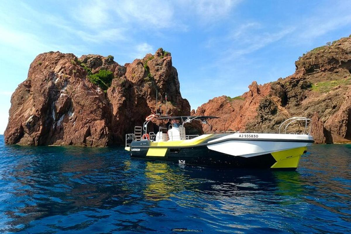 two people on a boat in the water near rocks