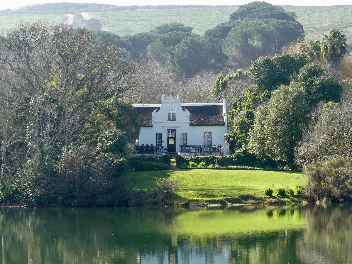 una casa blanca en una colina junto a un lago
