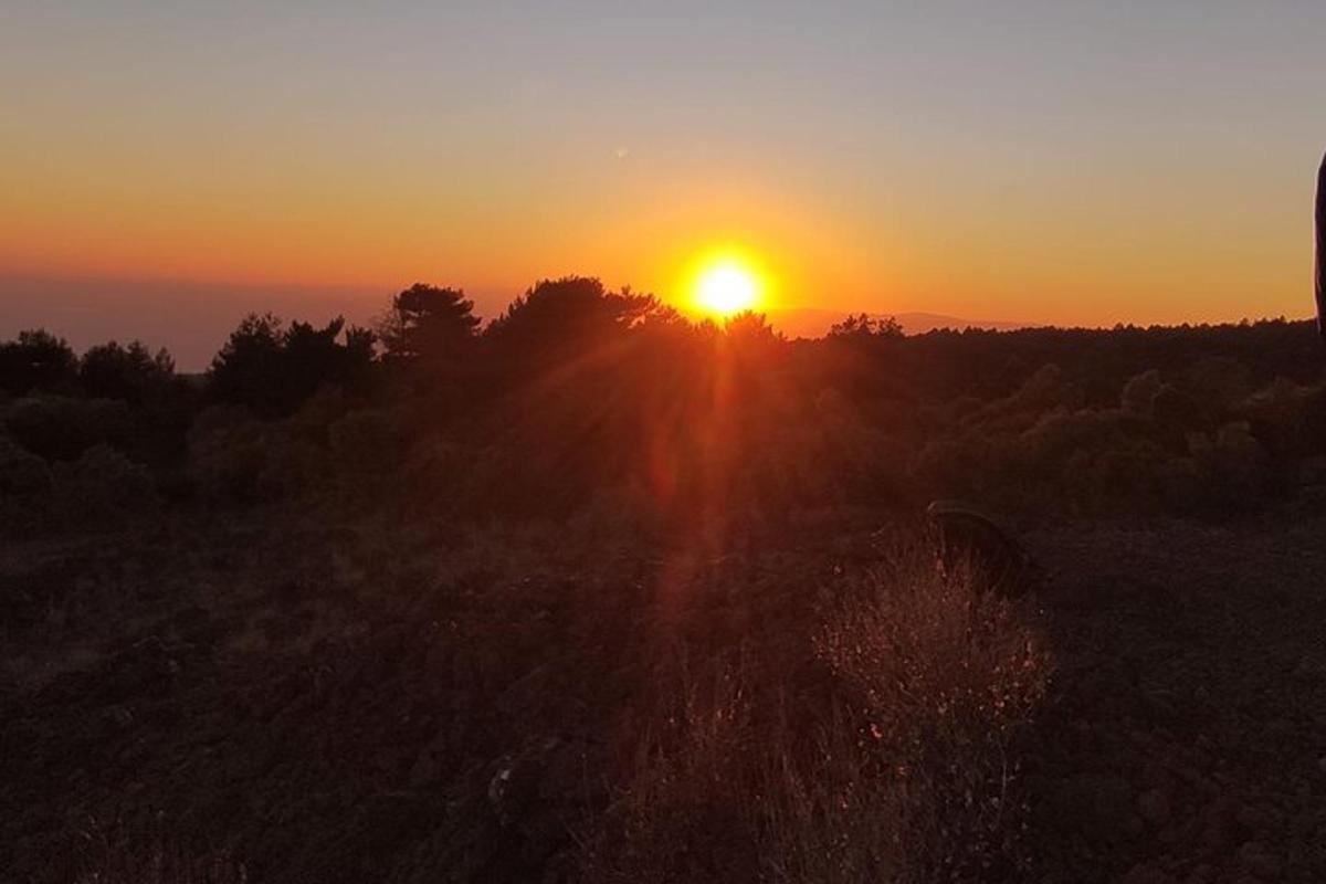 Západ slunce nad polem se zapadajícím sluncem v pozadí