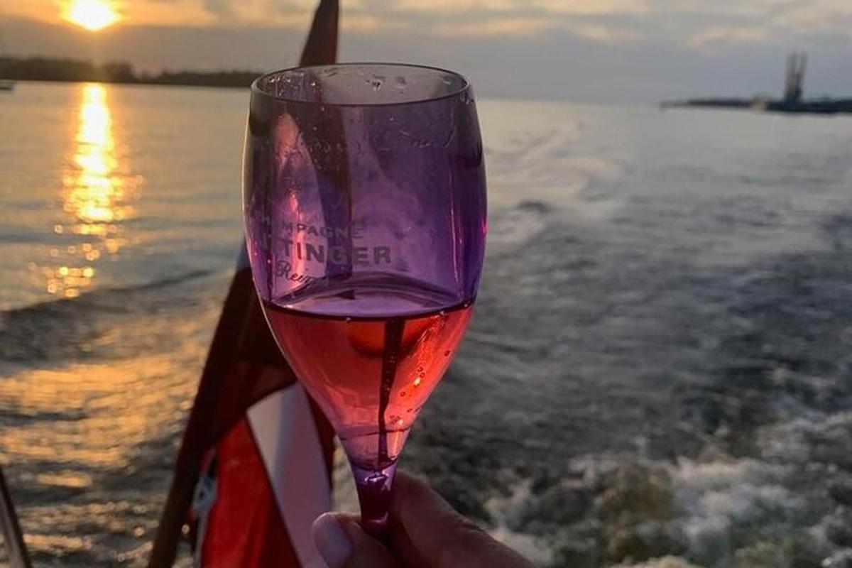 a person holding a wine glass in front of the water