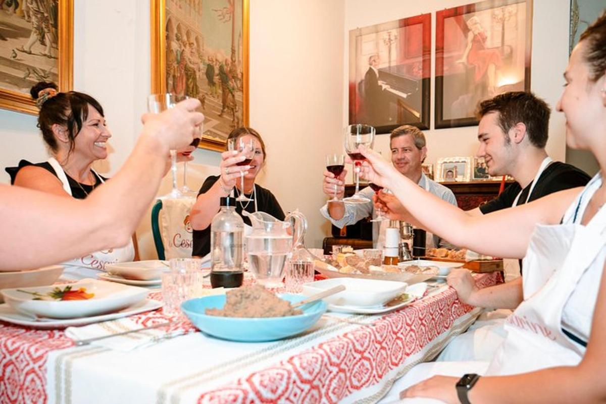 un grup de persones assegudes al voltant d'una taula bevent vi
