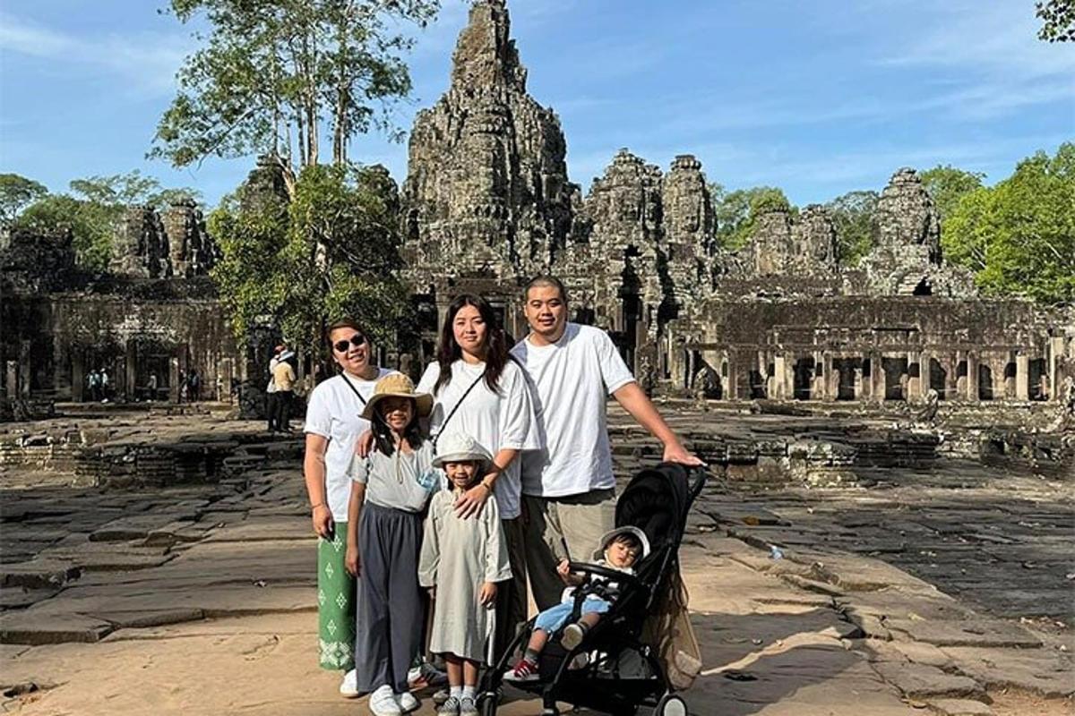 sebuah keluarga berpose untuk foto di depan sebuah kuil