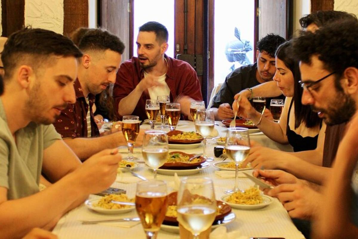 un gruppo di persone sedute attorno a un tavolo che mangiano cibo