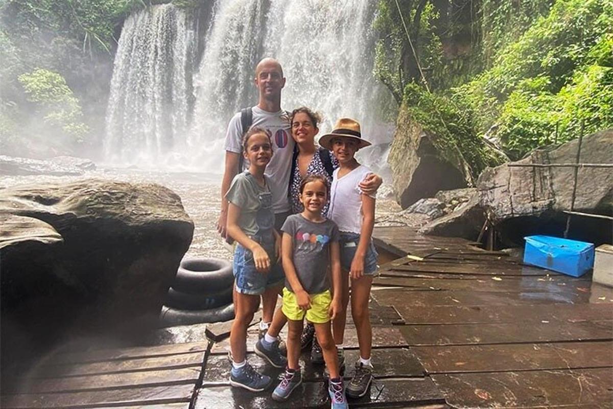 o familie stând în fața unei cascade