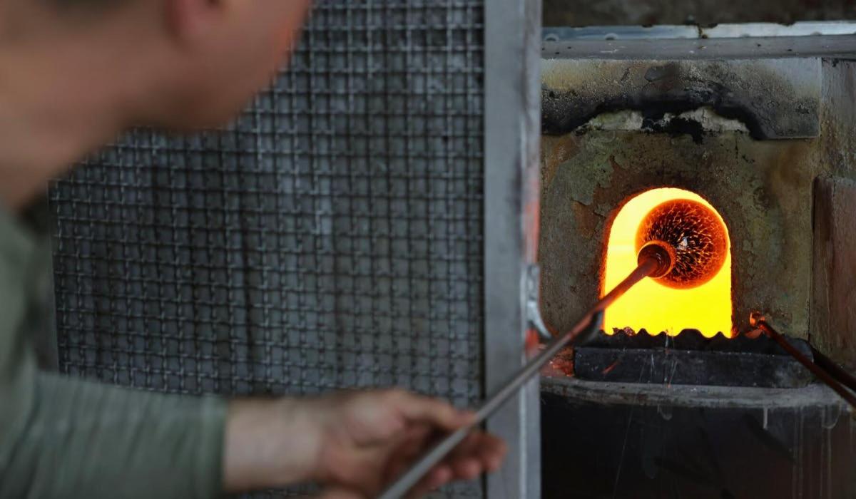một người đàn ông đang rèn lửa trong lò nướng