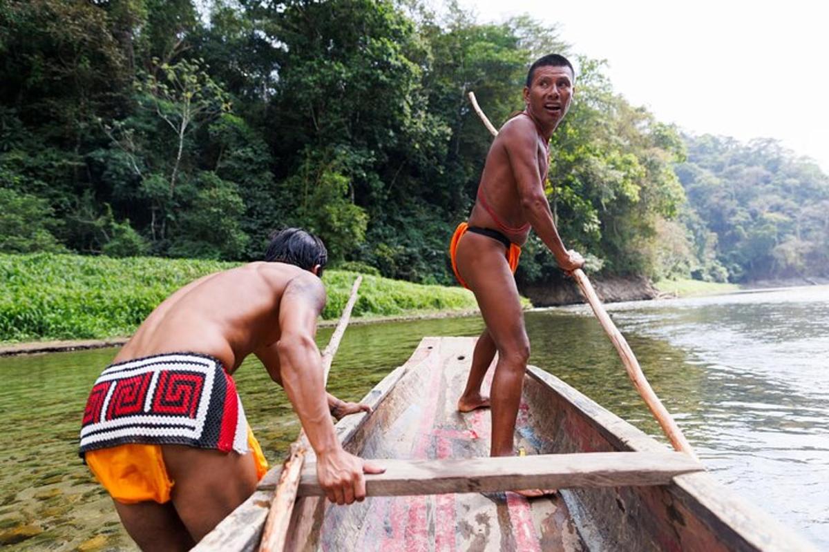 two men are rowing a boat on a river