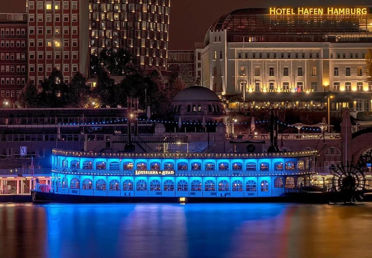 a building with blue lights on the water at night