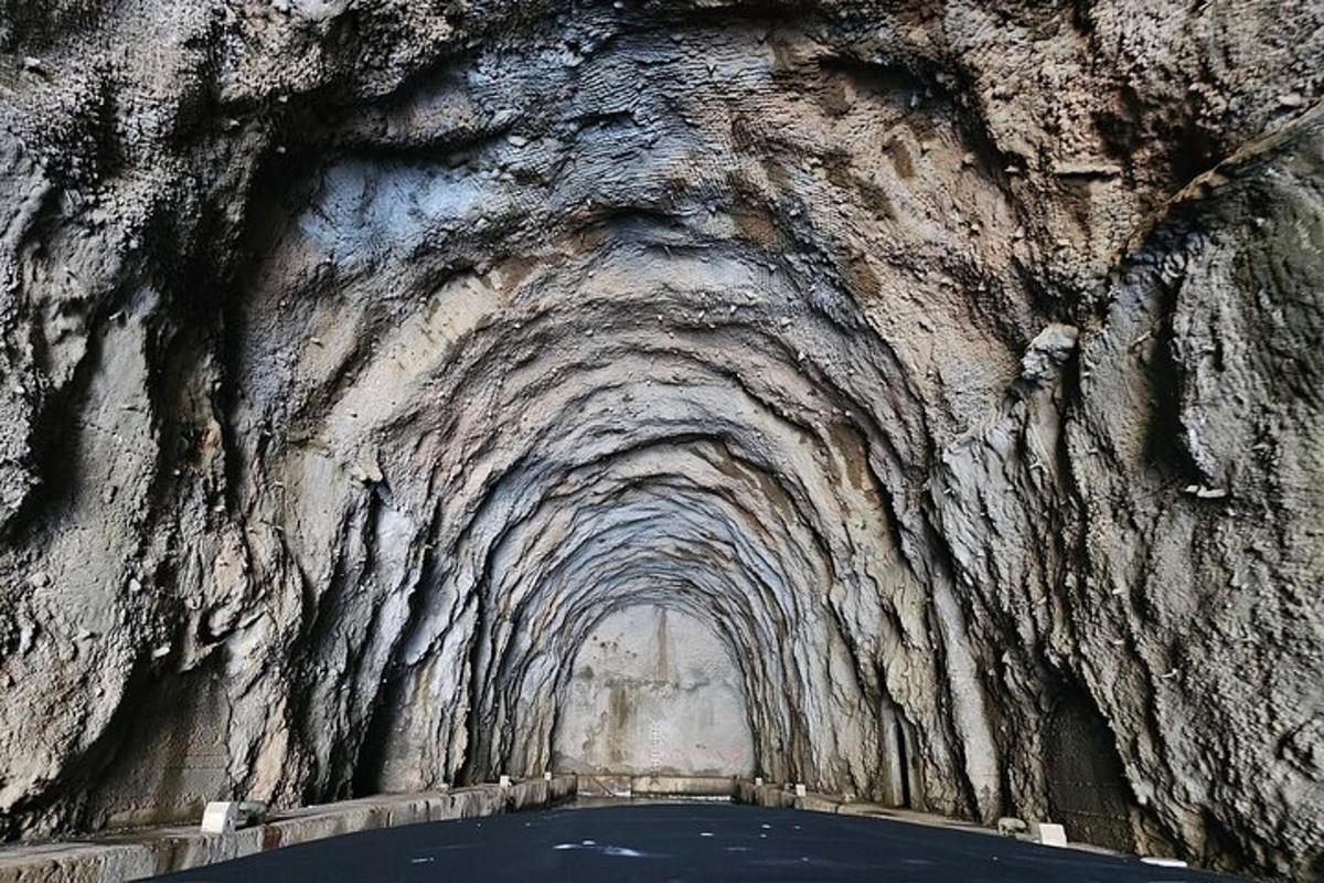un tunel într-un perete de stâncă cu apă în el