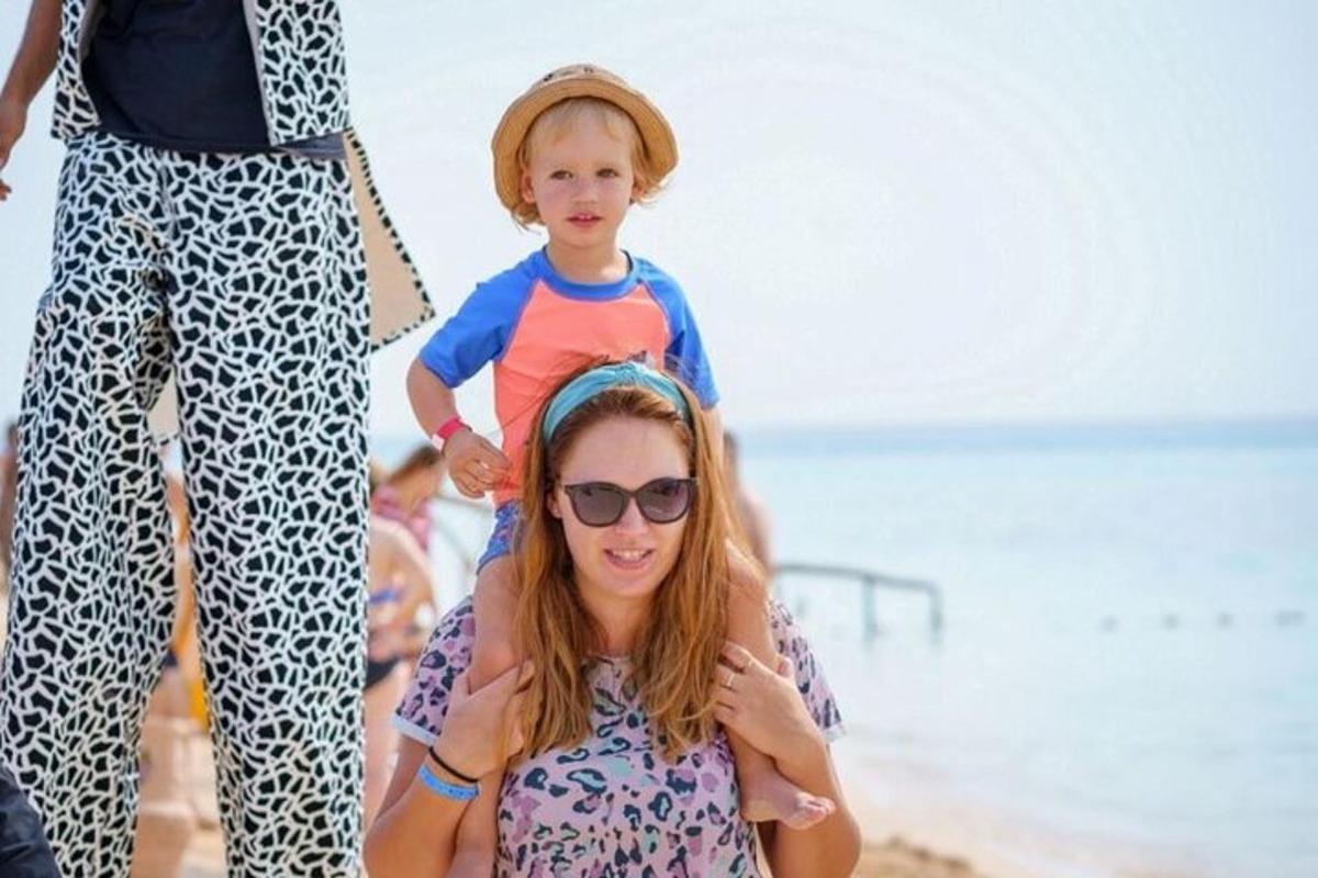a woman and a boy standing on the beach