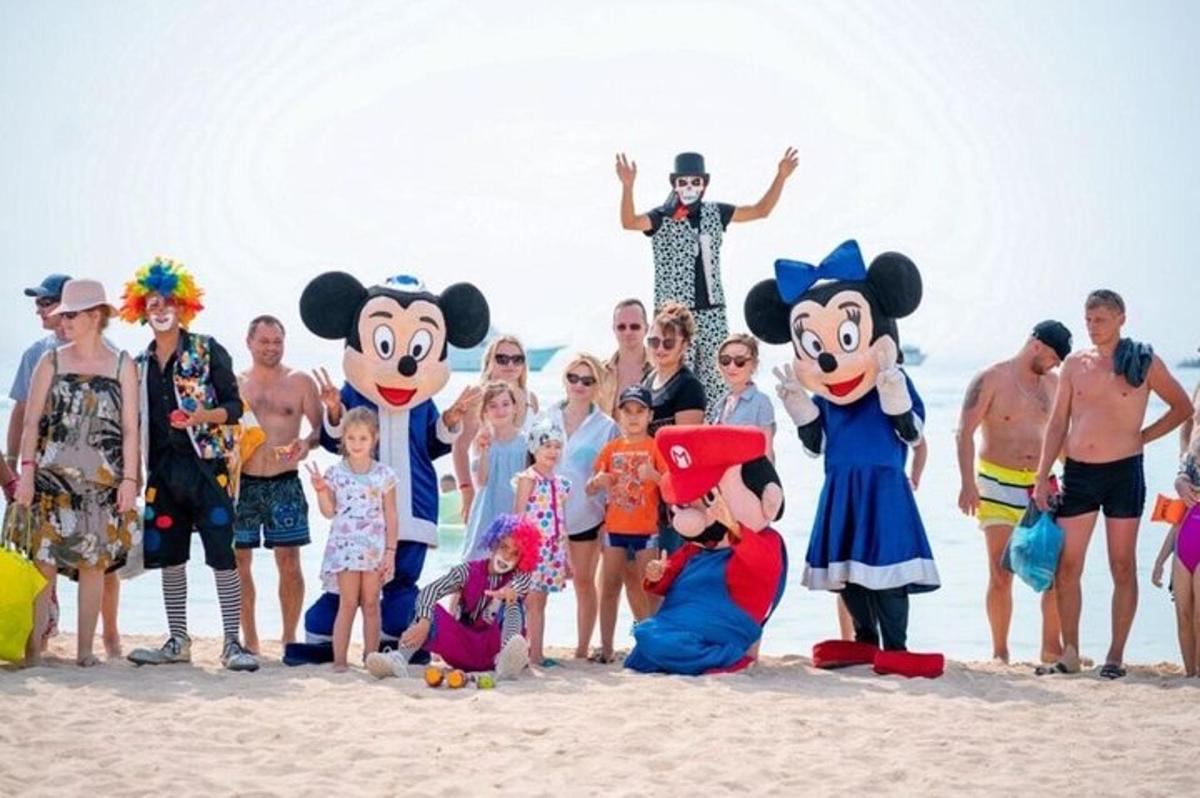 a group of people posing for a picture on the beach