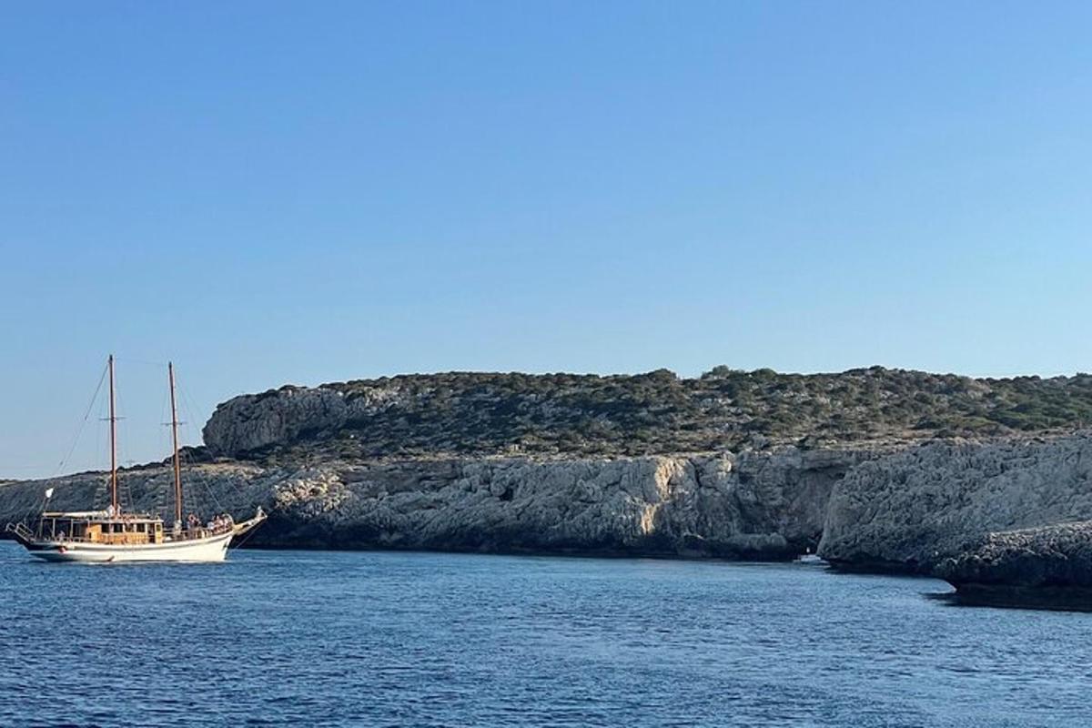una barca ferma nell'acqua accanto a una scogliera