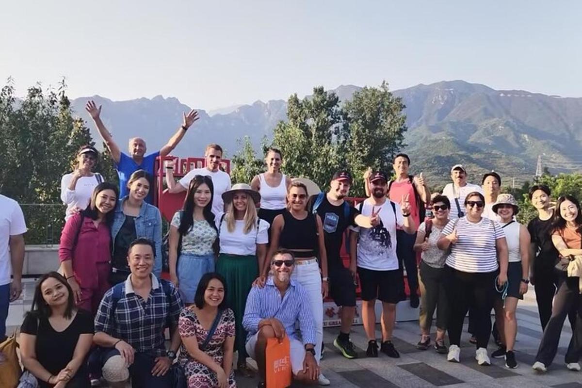 a group of people posing for a picture with mountains in the background