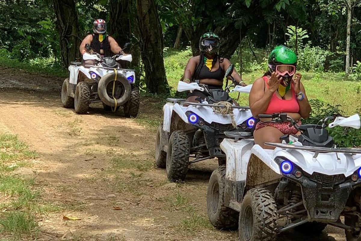 未舗装道路でATVに乗っている3人