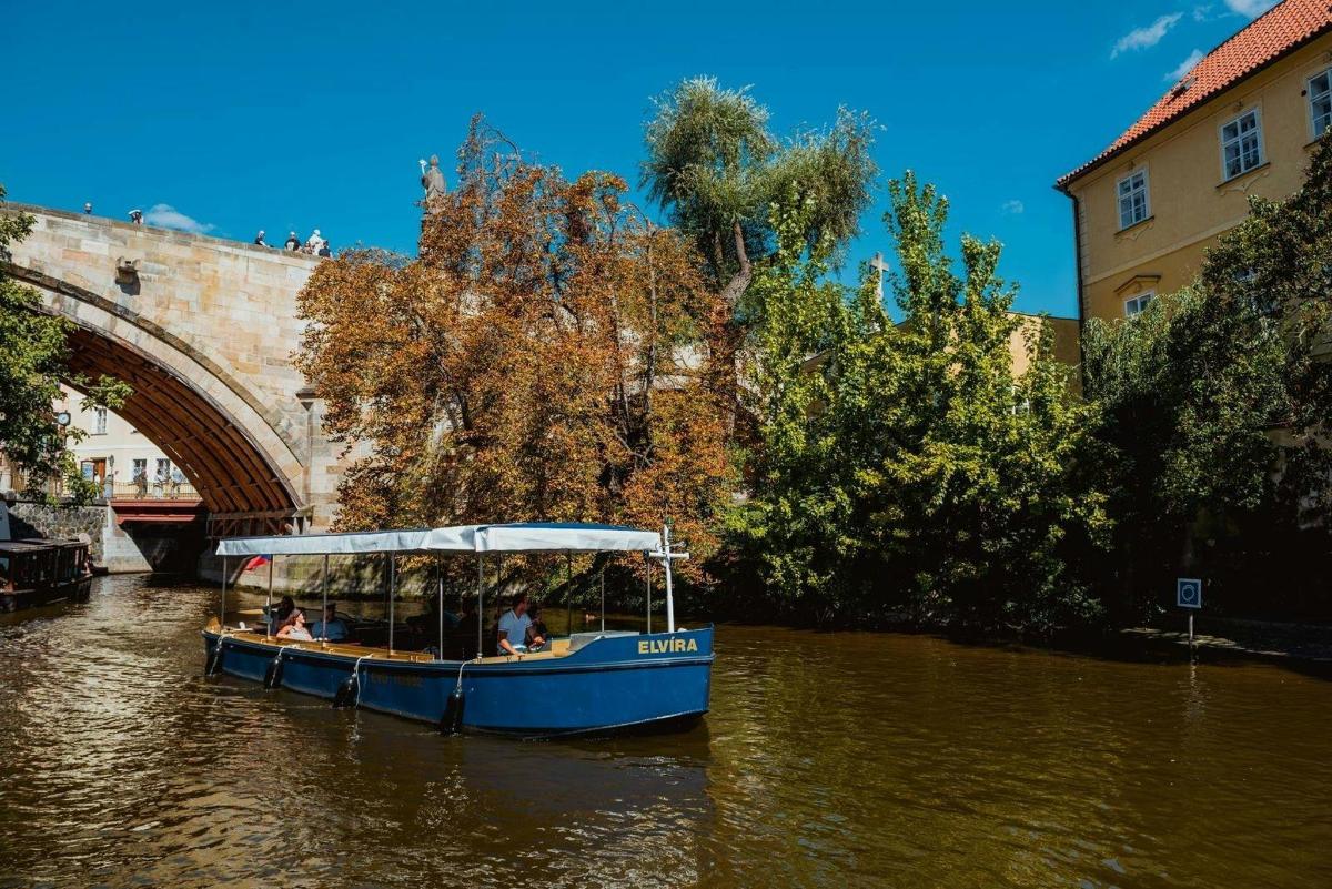 Un barco azul en el agua cerca de un puente.