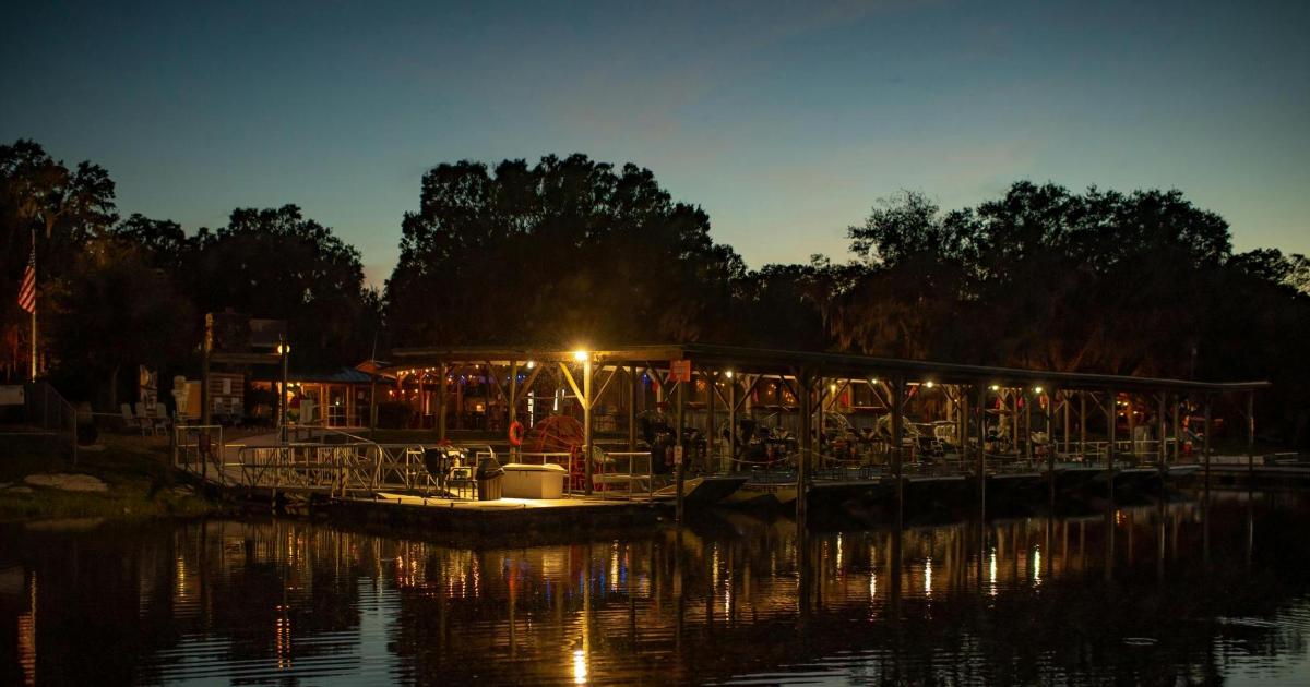a dock with a restaurant on the water at night