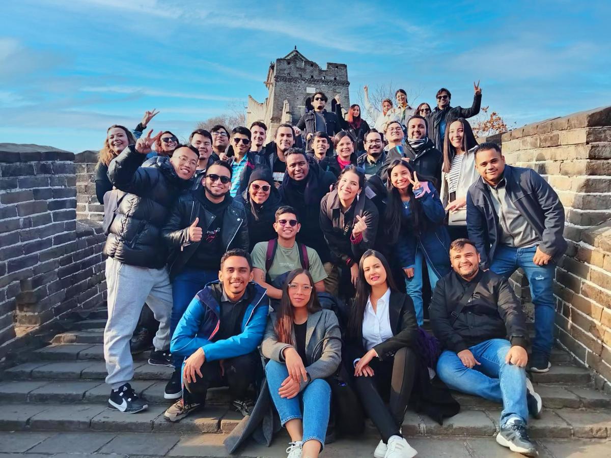 un grup de oameni care pozează pentru o fotografie pe un perete