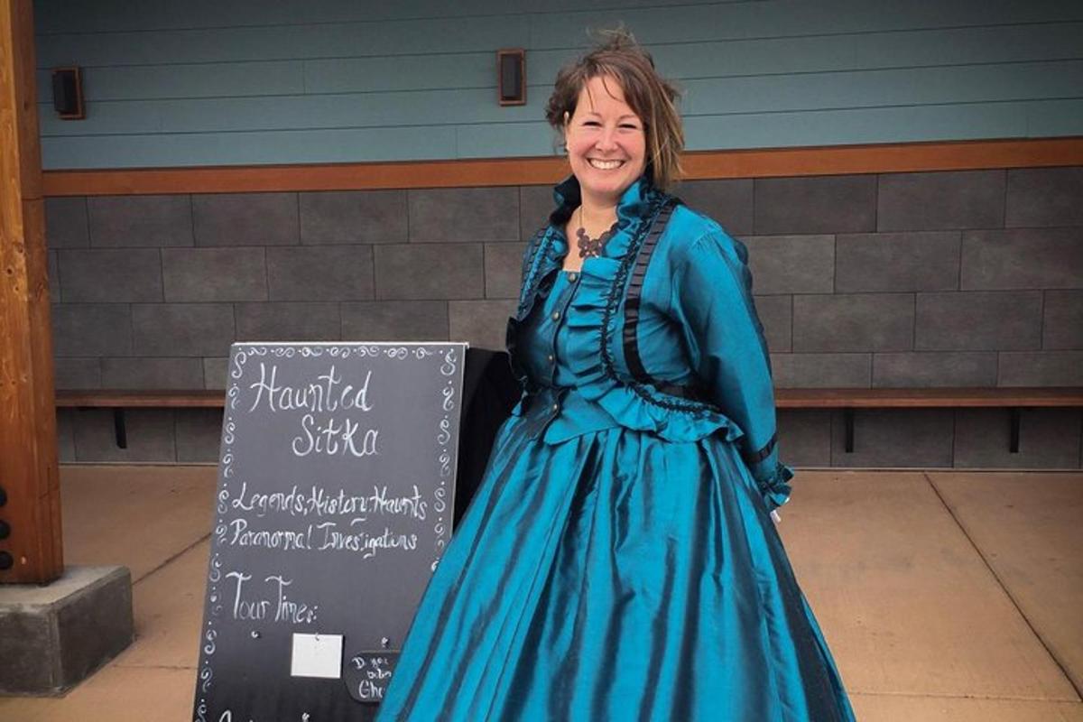 a woman in a blue dress standing next to a sign