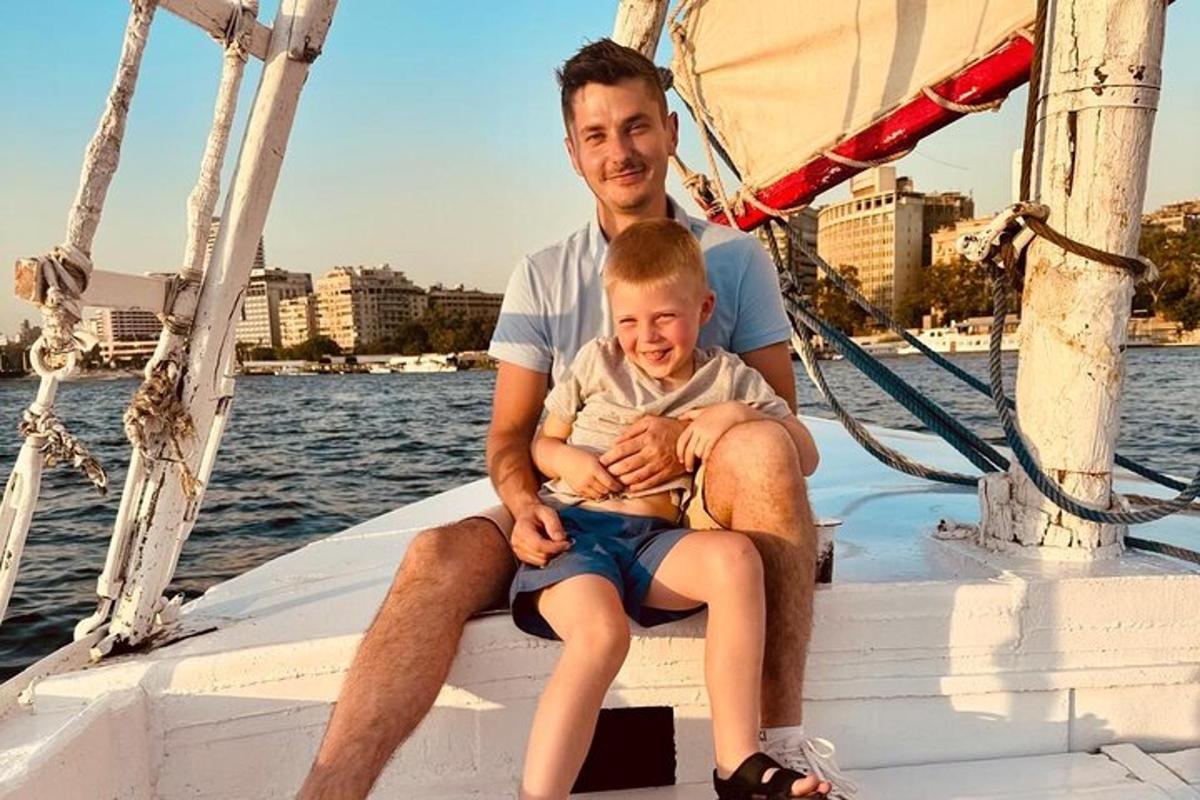 a man and a boy sitting on a sail boat