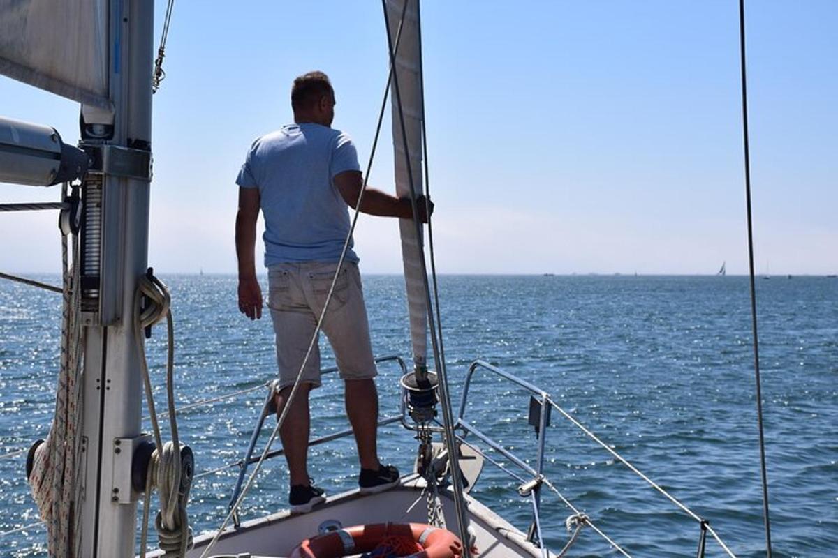 un uomo in piedi sulla prua di una barca a vela