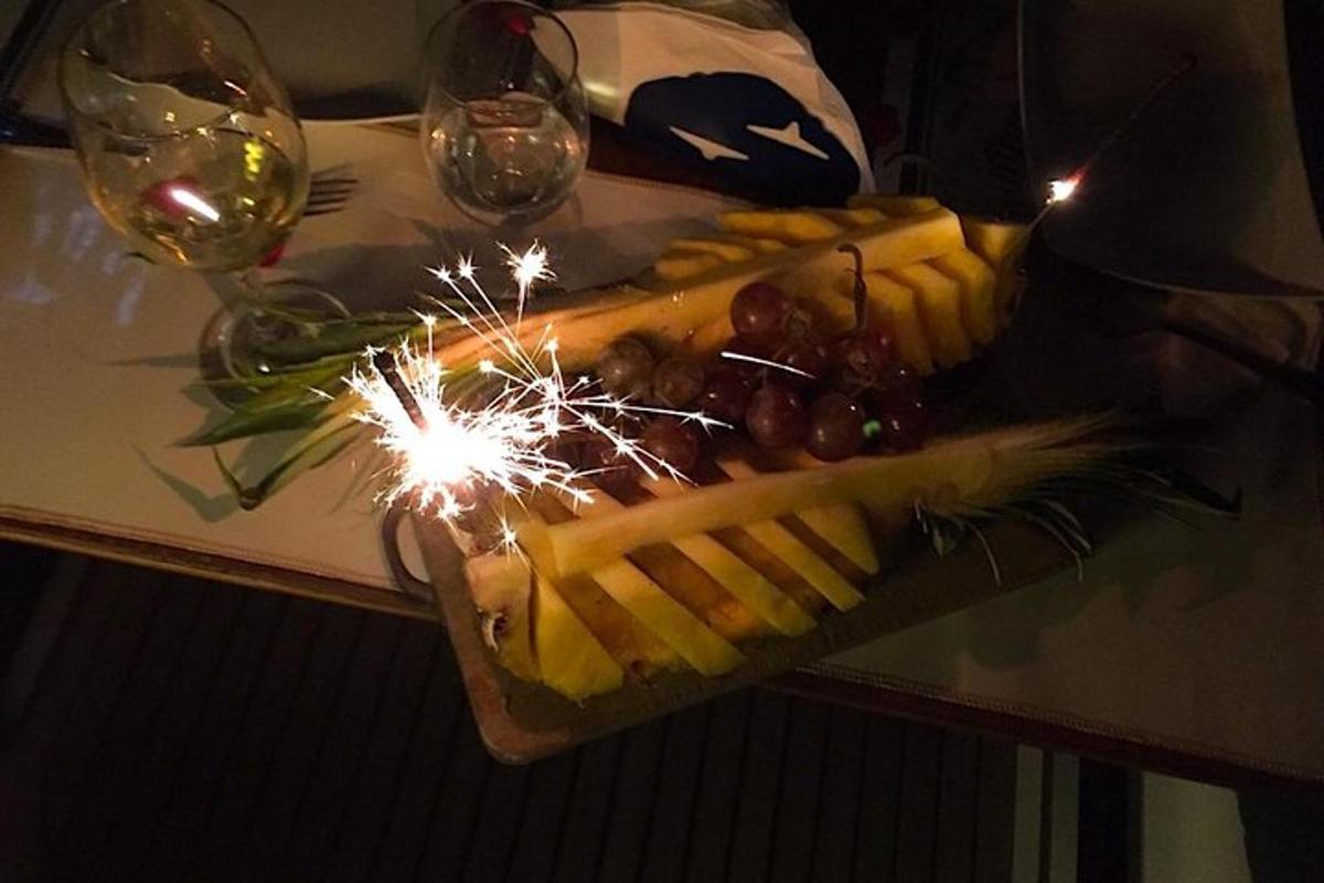 a display of cheese and fruit with a sparkler on a table