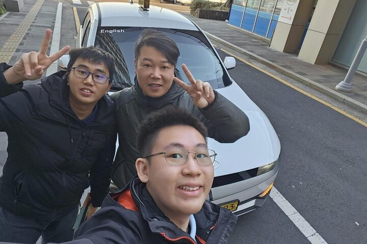 tre uomini in piedi davanti a un'auto bianca