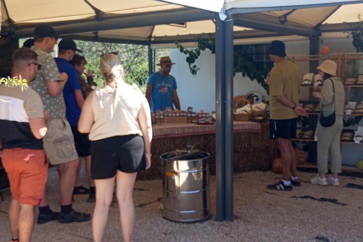 un grup de oameni care stă sub un cort la o piață