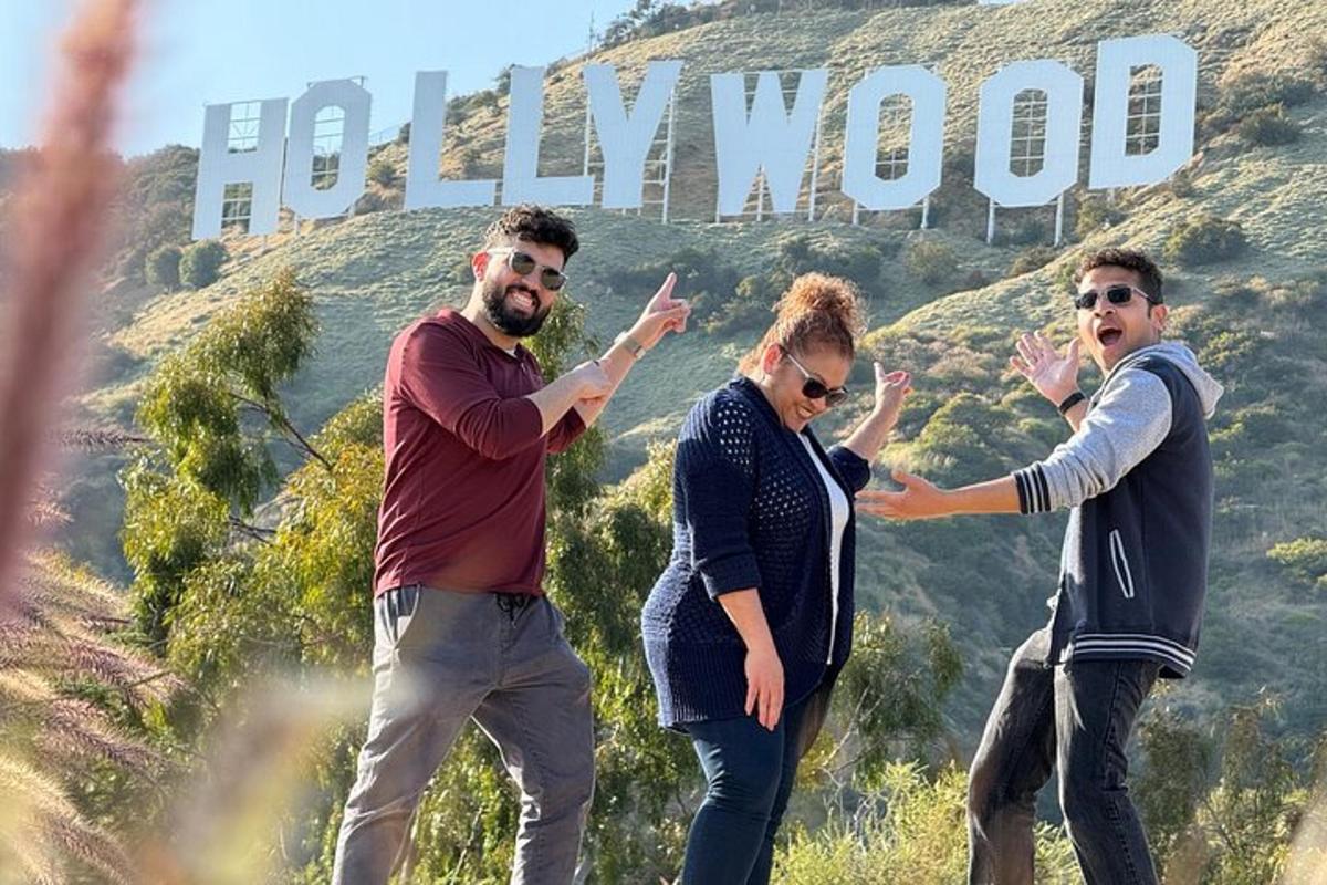 un gruppo di persone in piedi davanti al cartello di Hollywood