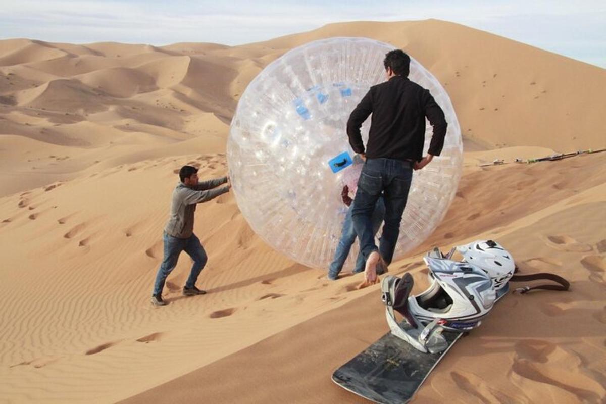 due uomini sono in piedi nel deserto con uno snowboard