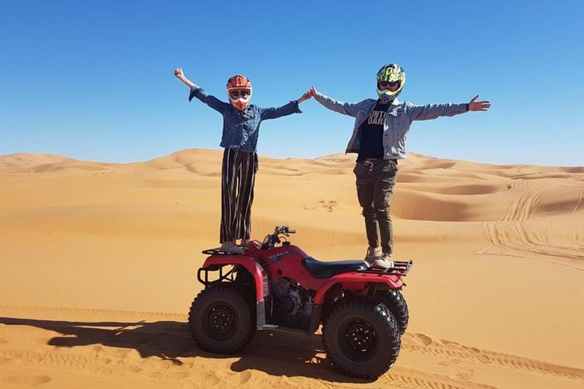 dues persones dempeus en un quad al desert