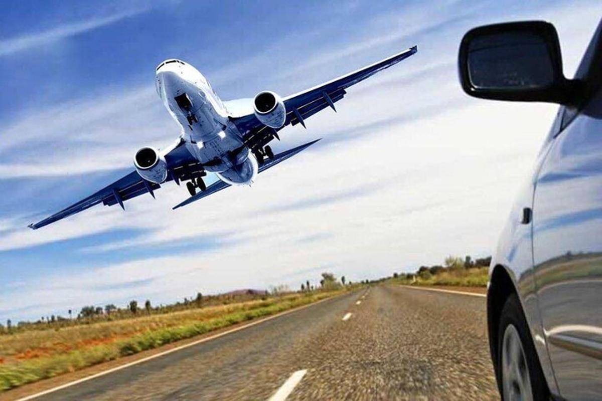 un aereo sta sorvolando una strada con un'auto