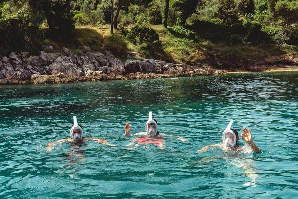 skupina tří lidí plave ve vodě
