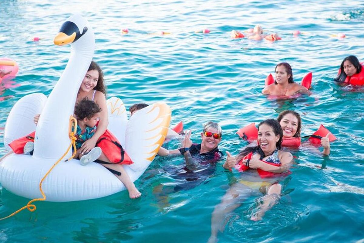 um grupo de pessoas na água com um cisne inflável