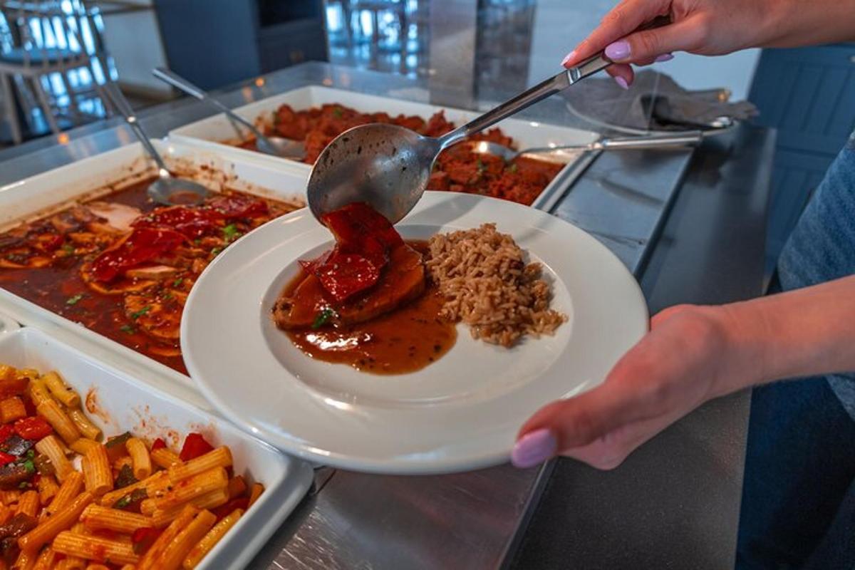 osoba držící talíř s jídlem lžící