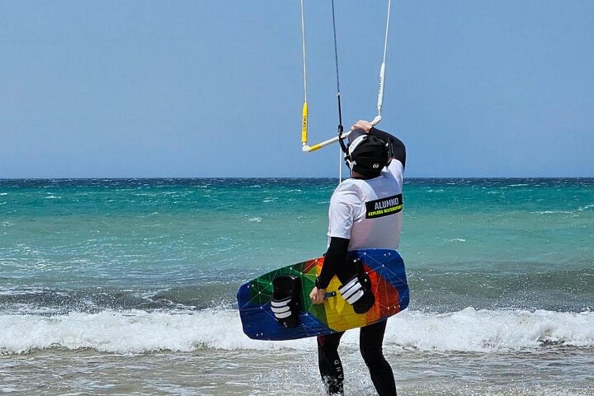 a man standing on the beach holding a board