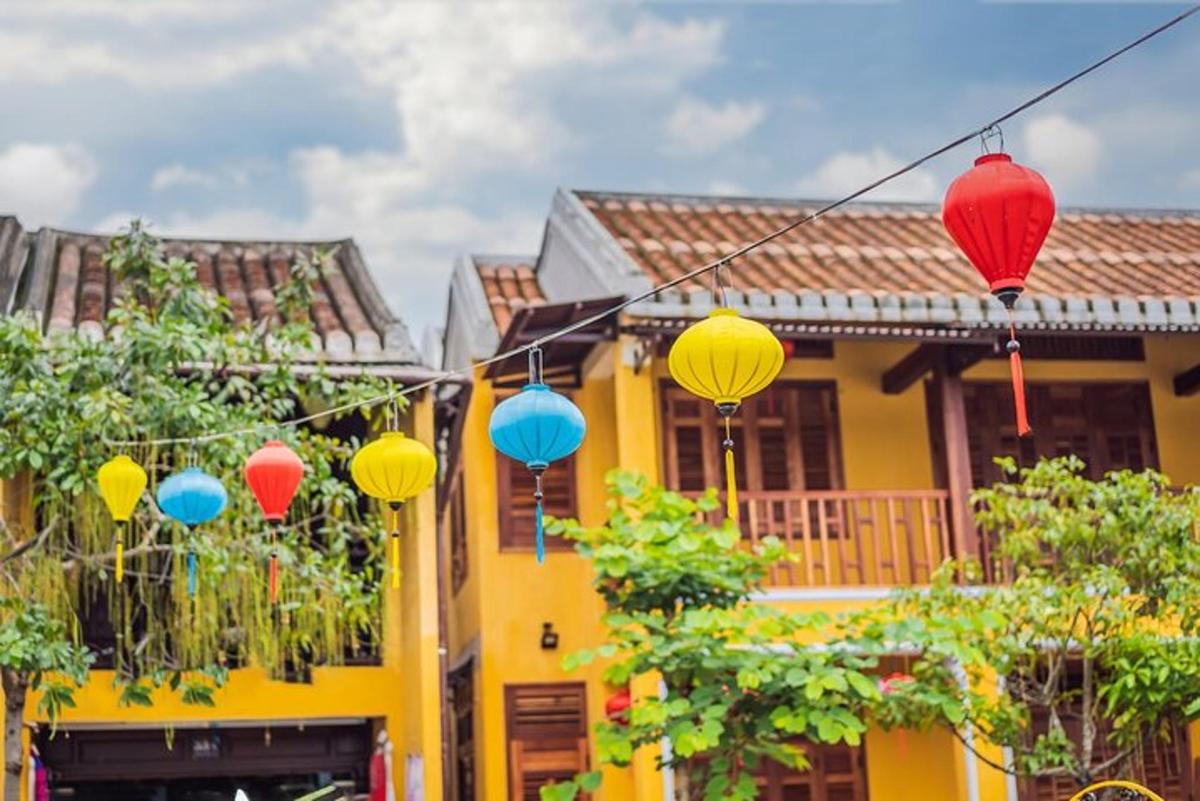 una casa groga amb fanals de colors al davant