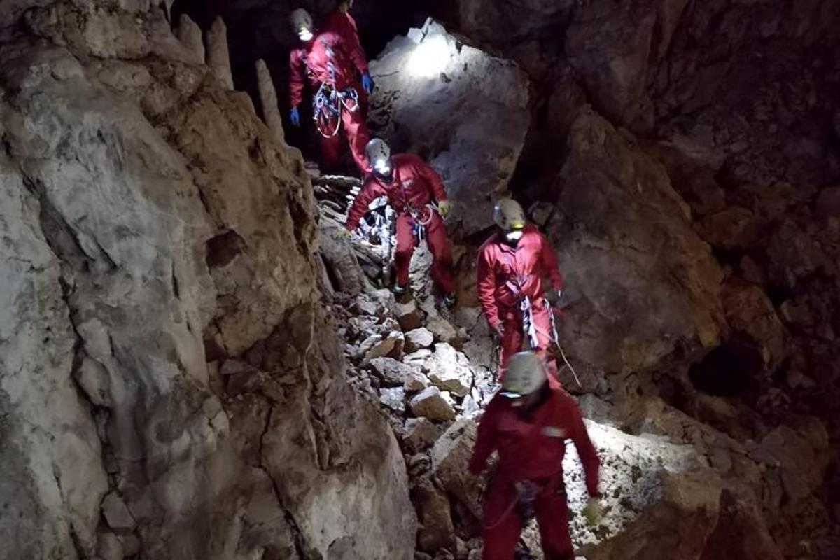 a group of people walking through a cave