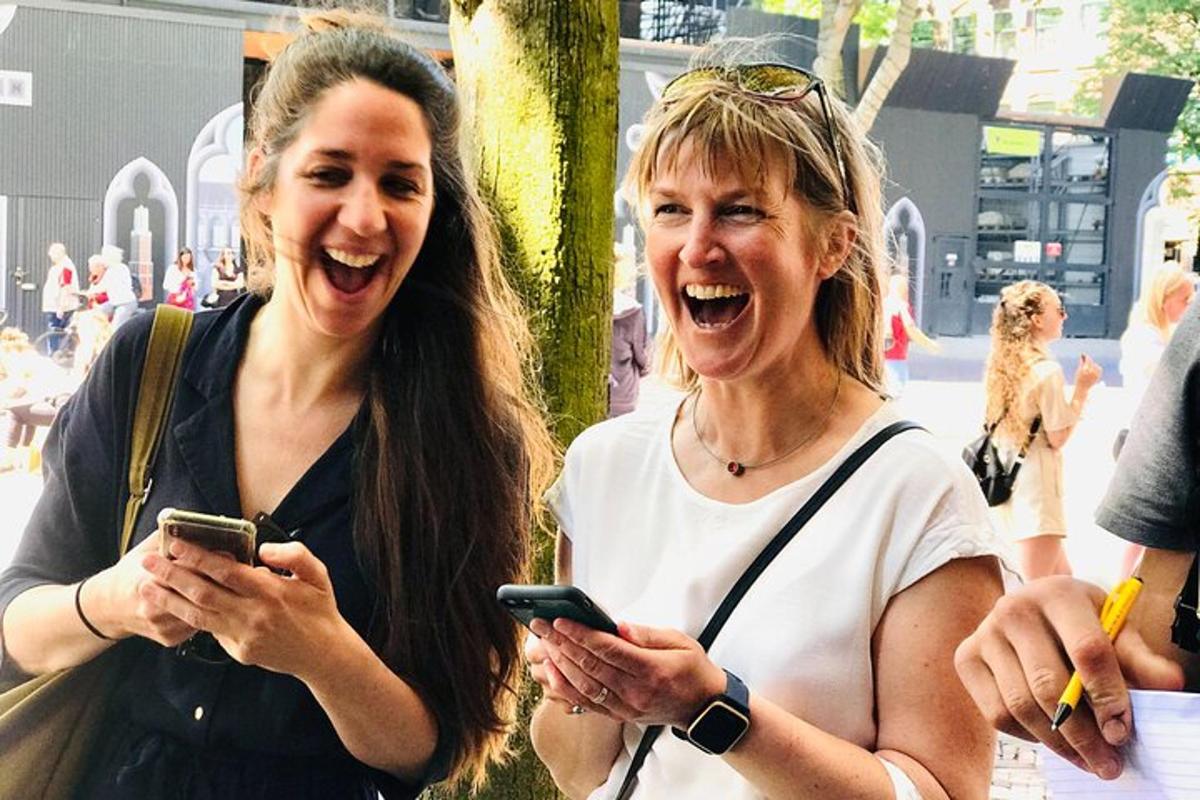 Kaks naist naeravad ja vaatavad oma mobiiltelefone