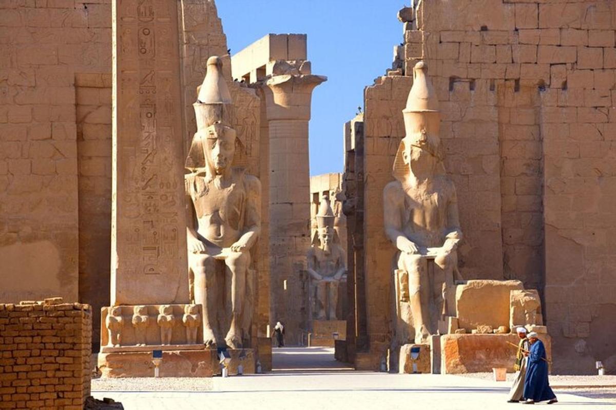 Una mujer caminando frente a un edificio con estatuas.