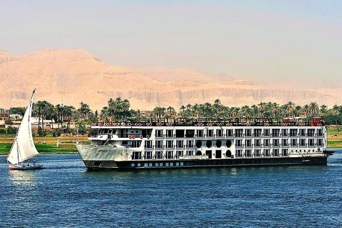 Un gran crucero en el agua con un velero