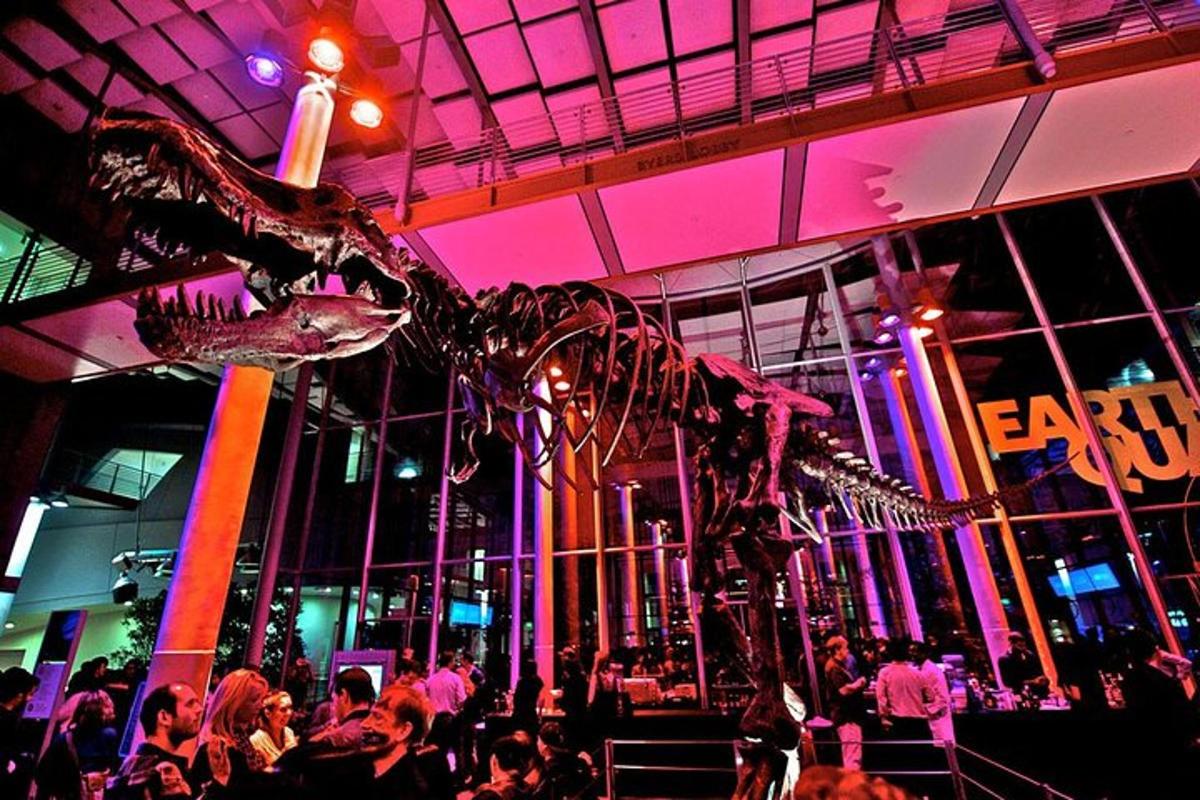 a dinosaur skeleton in a room with a crowd of people