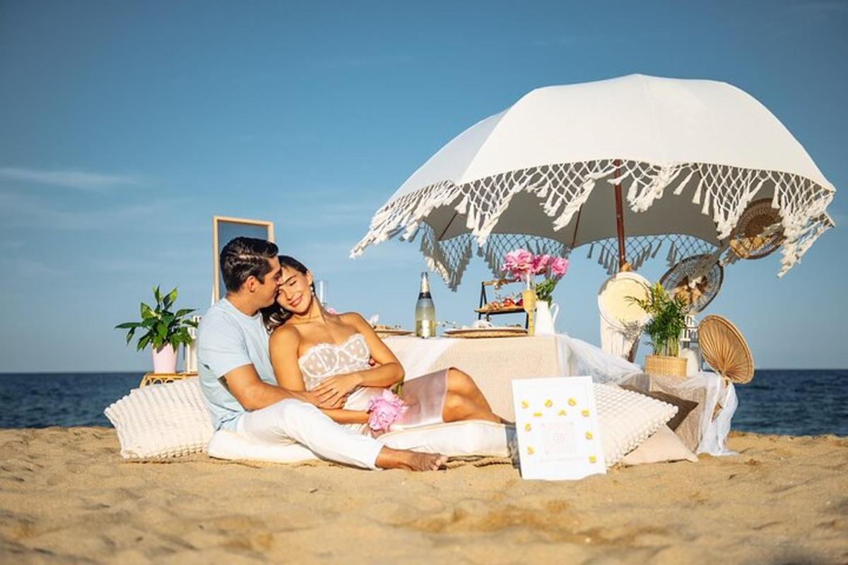 pasangan pengantin duduk di bawah payung di pantai