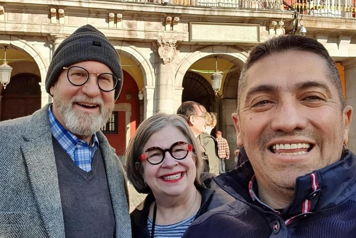 due uomini e una donna in piedi davanti a un edificio