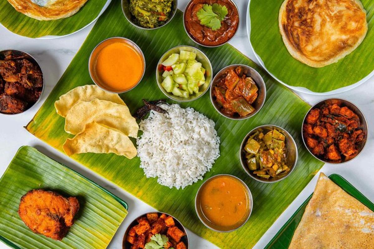 a table with plates of food on a banana leaf