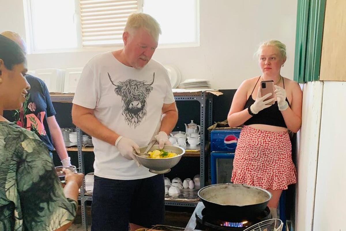 a man and a woman standing in a kitchen preparing food
