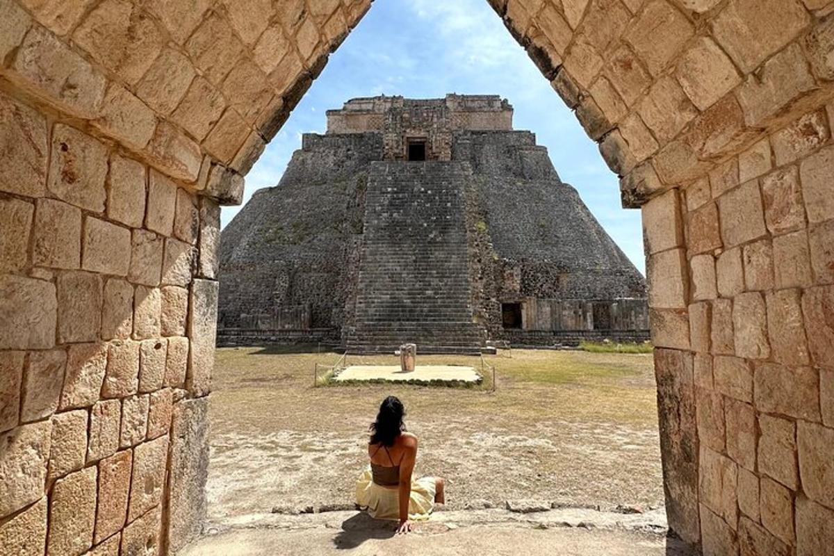 žena sedící před pyramidou