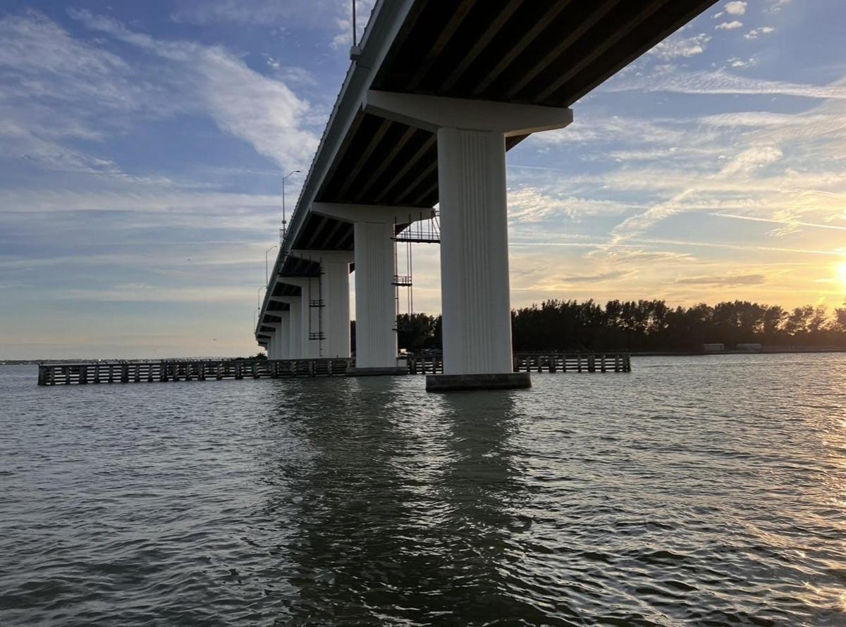 een brug over een watermassa bij zonsondergang