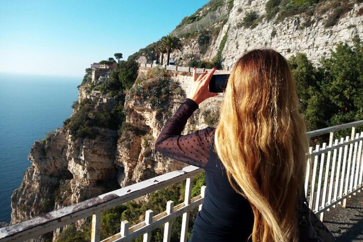 bir uçurumun fotoğrafını çeken bir kadın